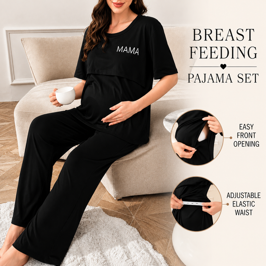 A pregnant woman wearing a black maternity pajama set with 'MAMA' printed in white on the chest, sitting on a beige sofa. The set includes a short-sleeve top and matching pants.